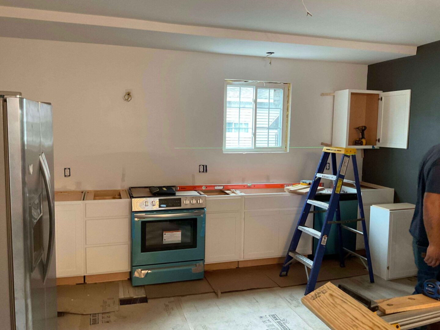 A kitchen being remodeled with the help of a ladder.