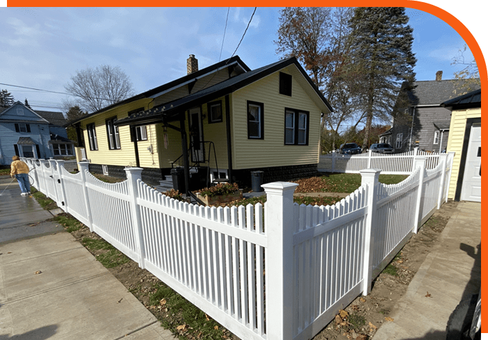 A house with a fence around it and a sidewalk.
