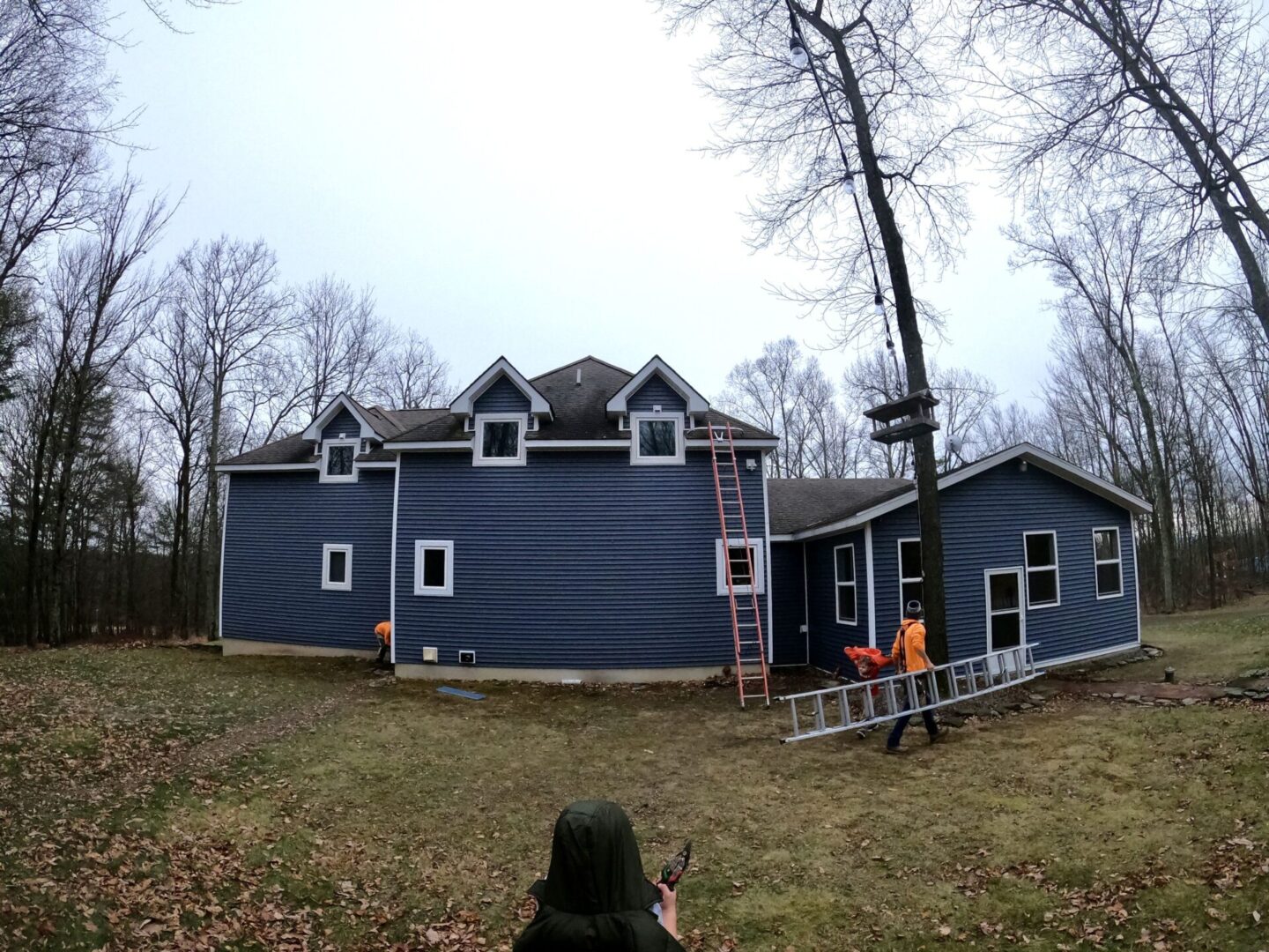 A person standing in front of a house under construction.