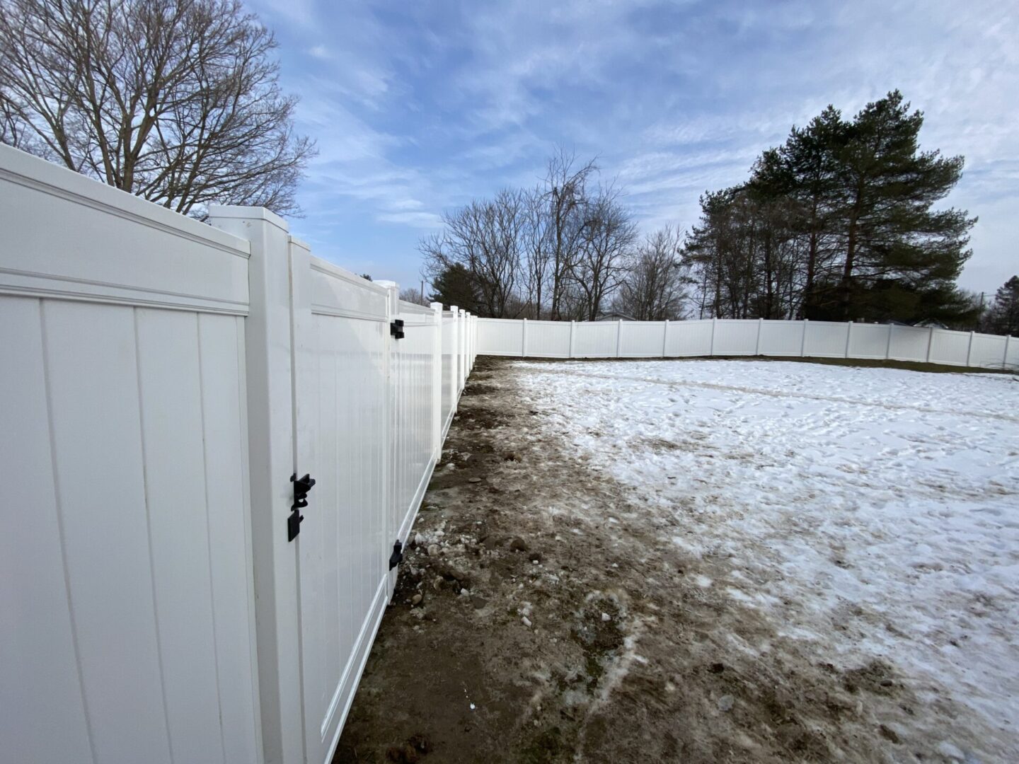 A white fence with snow on the ground